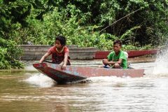 Local Lao fisher men riding their longtail boats on the Mekong, 4000 Islands